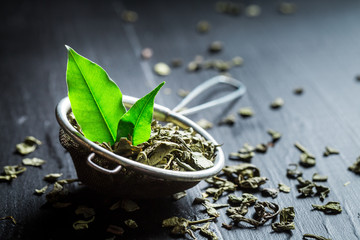 Tasty green tea in old metal strainer
