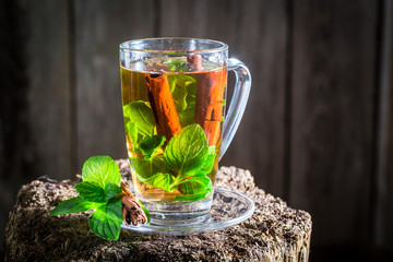 Hot tea with cinnamon bark and green leaves