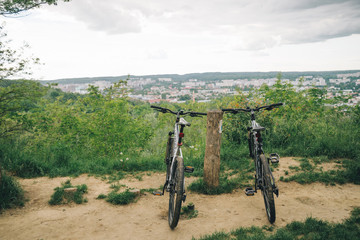 Fototapeta na wymiar two bicycles stand wth city view on background