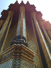 stucco buddha under chapel roof with beautiful pole at Wat Phra Kaew, Temple of the Emerald Buddha , Bangkok Thailand
