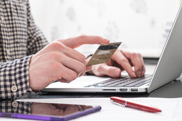 Hands with plastic card and laptop