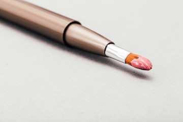 Pink lip gloss on a make-up brush