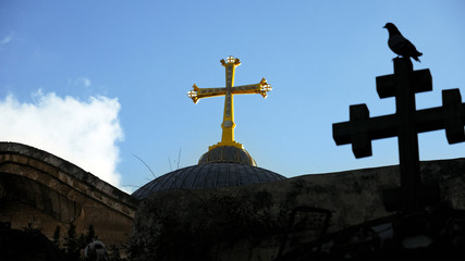 Golden cross over Temple of the Holy Sepulcher church in Jerusalem. The Holy Sepulchre Church is...