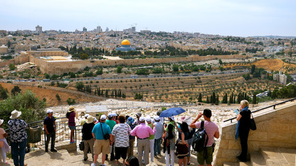 Fototapeta premium The guide shows the Jerusalem Old City view to the tourists. Mount of Olives is a famous and sacred Christian's place and it has a fantastic view to the Old Jerusalem.
