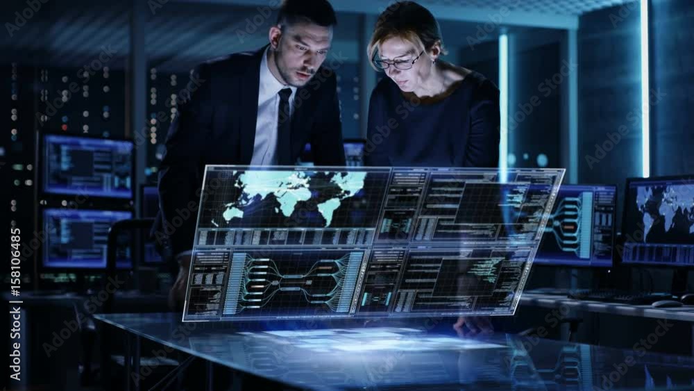 Poster male and female government agents use touchscreen interactive 3d panel in big monitoring room full o