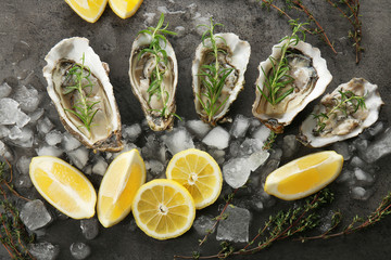 Fototapeta na wymiar Tasty fresh oysters with sliced juicy lemon and ice on dark background. Aphrodisiac food for increasing sexual desire