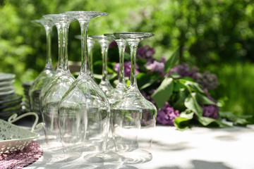 Set of glassware on table with lilac decoration, closeup