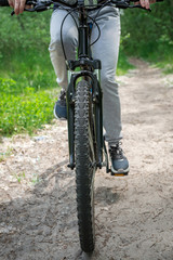 A trip on a mountain bike along the forest path. Sports and the concept of active life in the summer. Vertical frame