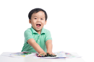 Portrait of cheerful asian boy playing with watercolors