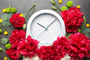 Beautiful composition with flowers and clock on gray background