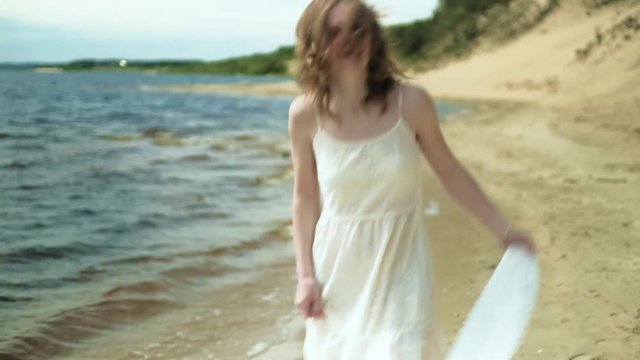 Woman In white dress staying on a beach with flower at the sunny day 4k