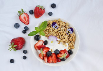 Yogurt with granola and fruits, blueberries, strawberries, cherry, apple, banana, healthy breakfast