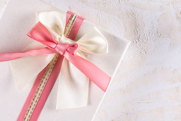 Flat lay box with bow above wooden background planks