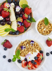 Yogurt with granola and fruits, blueberries, strawberries, cherry, apple, banana, healthy breakfast