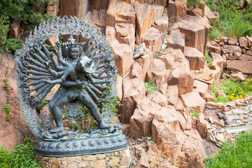 Tantric Deities statue in Ritual Embrace located in a mountain garden