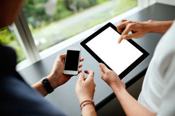 Two men using tablet and smartphone