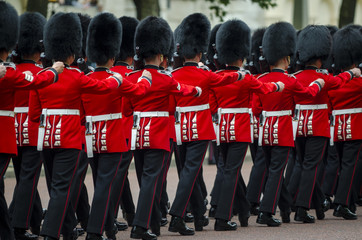 Fototapeta premium Żołnierze w klasycznych czerwonych płaszczach maszerują wzdłuż The Mall w Londynie w wielkim spektaklu Trooping the Colour Królewskiej Gwardii Królowej