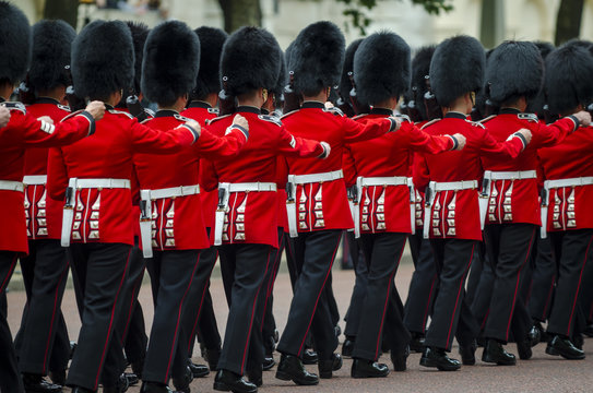 Fototapeta Soldiers in classic red coats march along The Mall in London, England in a grand Trooping the Colour spectacle of the Queen's Royal Guard