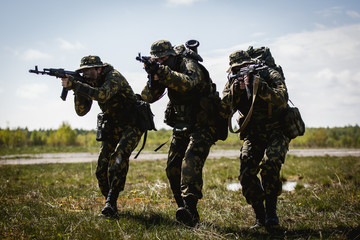 Fototapeta premium A group of special forces in a field with weapons