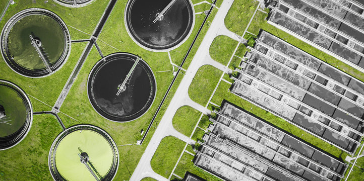 Sewage farm. Static aerial photo looking down onto the clarifying tanks and green grass. Geometric background texture.