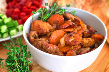 Stewed lamb with onions and carrots. Selective focus. Wooden background. Close-up. Top view