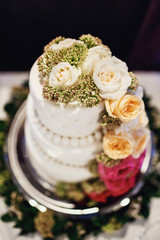 Obraz na płótnie Canvas White wedding cake decorated with green and pink flowers