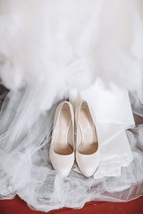 Fototapeta na wymiar White shoes stand on wedding dress
