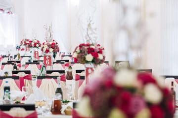 Chairs decorated with pink ribbons stand at dinner tables in the restaurant