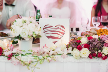 Frame in form of a heart stands on a dinner table