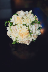White wedding bouquet lies on leather chair