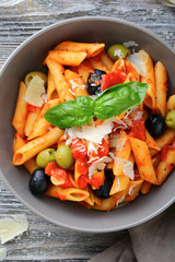 Penne Pasta in tomato sauce with olive and parmesan. Top view
