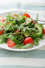 Green Avocado Salad with cherry tomatoes and arugula closeup