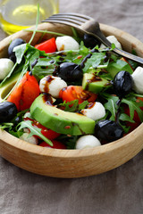 Fresh Avocado Salad with cherry tomatoes, olive, mozzarella and arugula