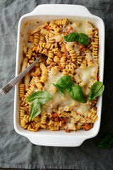 Pasta Bolognese in white baking dish on a linen napkin. Top view