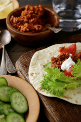 Closeup Mexican Tacos with ground beef and lettuce, tomato, cucumber