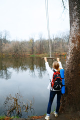 Fototapeta na wymiar Woman traveler with bungee in the hands near autumn river