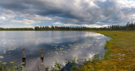 Great panoramic view on lake in marshland area. Small wooden bridge on a foreground. Northern Finland. - 158140869