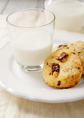 Several cookies on a plate with milk