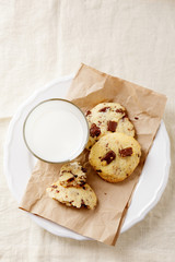Rustic cookies on a paper with glass of milk