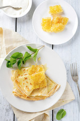 Pancakes with honey on a white plate