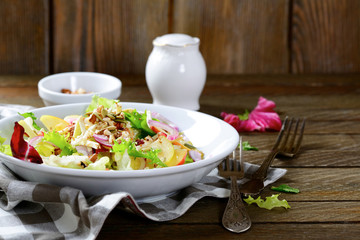 Salad of fruit and walnuts on a white plate
