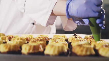 Food nozzle squeezing filling into pastry cases