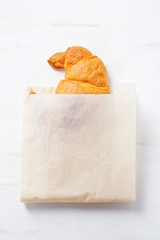 Delicious fresh croissant in paper packaging