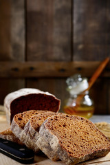 Slices of rye bread and honey on a wooden background