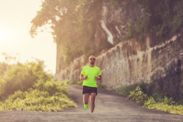 Obraz premium Jogging on the suburb road at sunset / sunrise time.