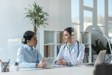 doctor talking with patient during medical consultation at office