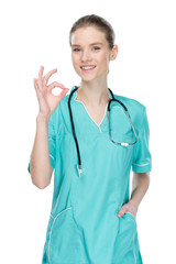 young smiling nurse with stethoscope showing ok sign isolated on white