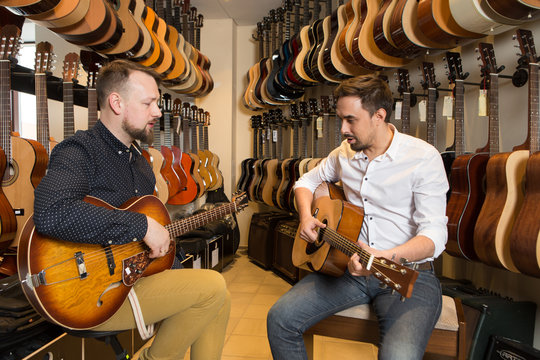 People playing guitar in shop