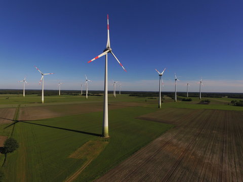 Windenergieanlagen auf Feld vor Wald