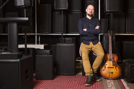 Guitarist sitting on guitar combo